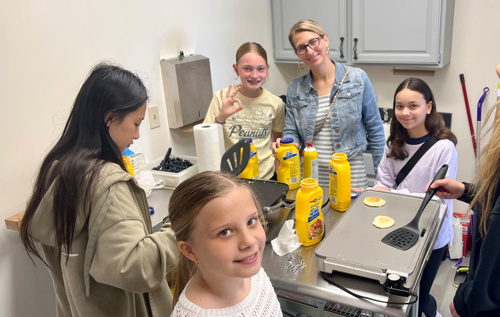 Kids and a leader making pancakes together in the Anchor Point kitchen