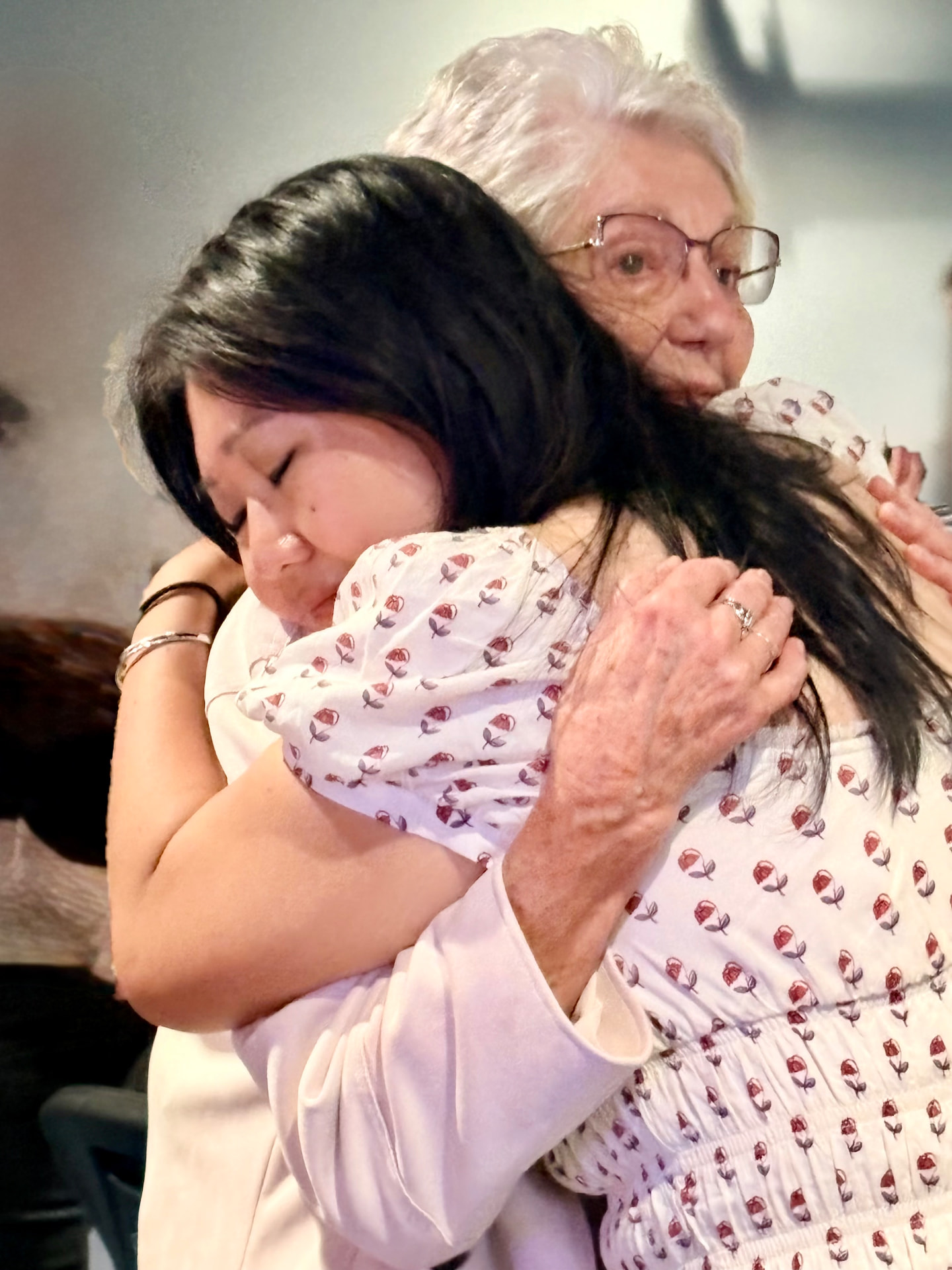 Two women share a long hug after a gathering at Anchor Point Church