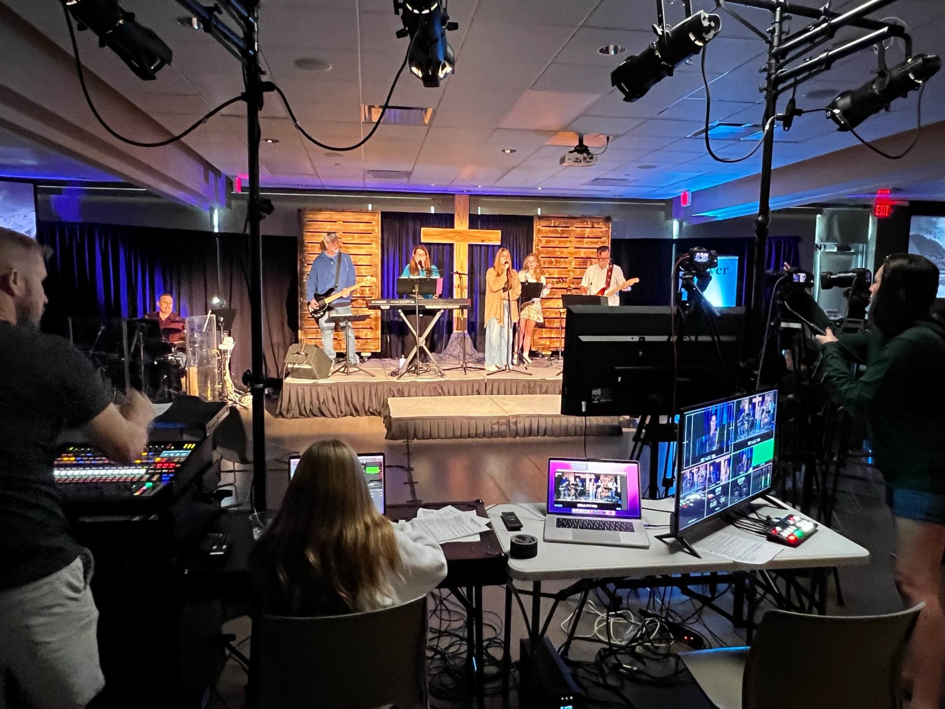 The production booth at Anchor Point, with cameras and a mixing desk facing the worship stage.